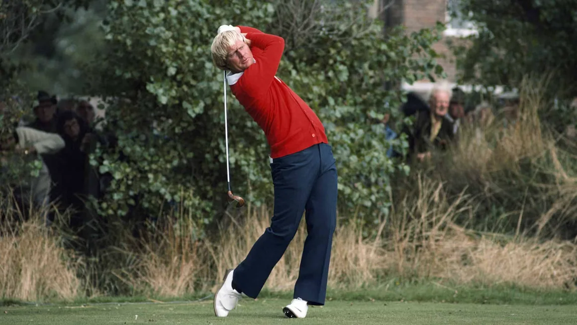 Jack Nicklaus in a red cardigan and navy trousers at the top of his follow-through