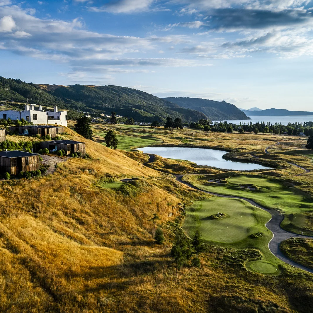 Fairways of The Kinloch Club winding through tussock above Lake Taupō