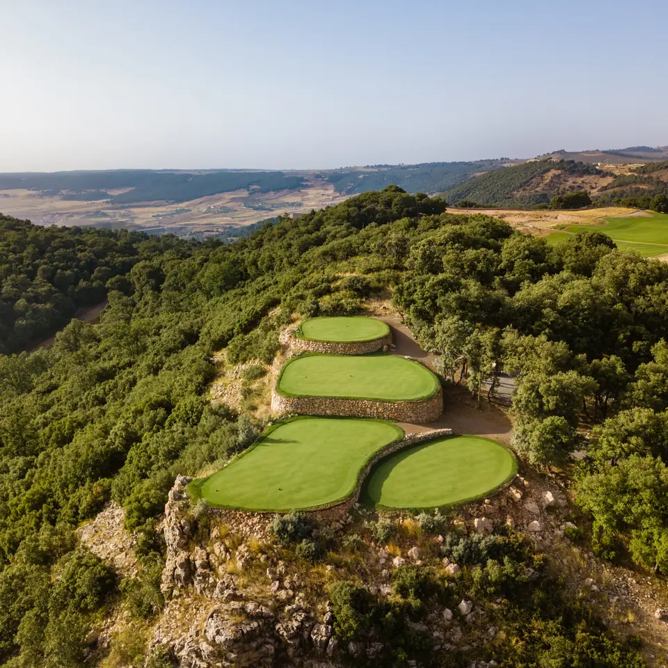 Terraced greens on a wooded ridge at Michlifen