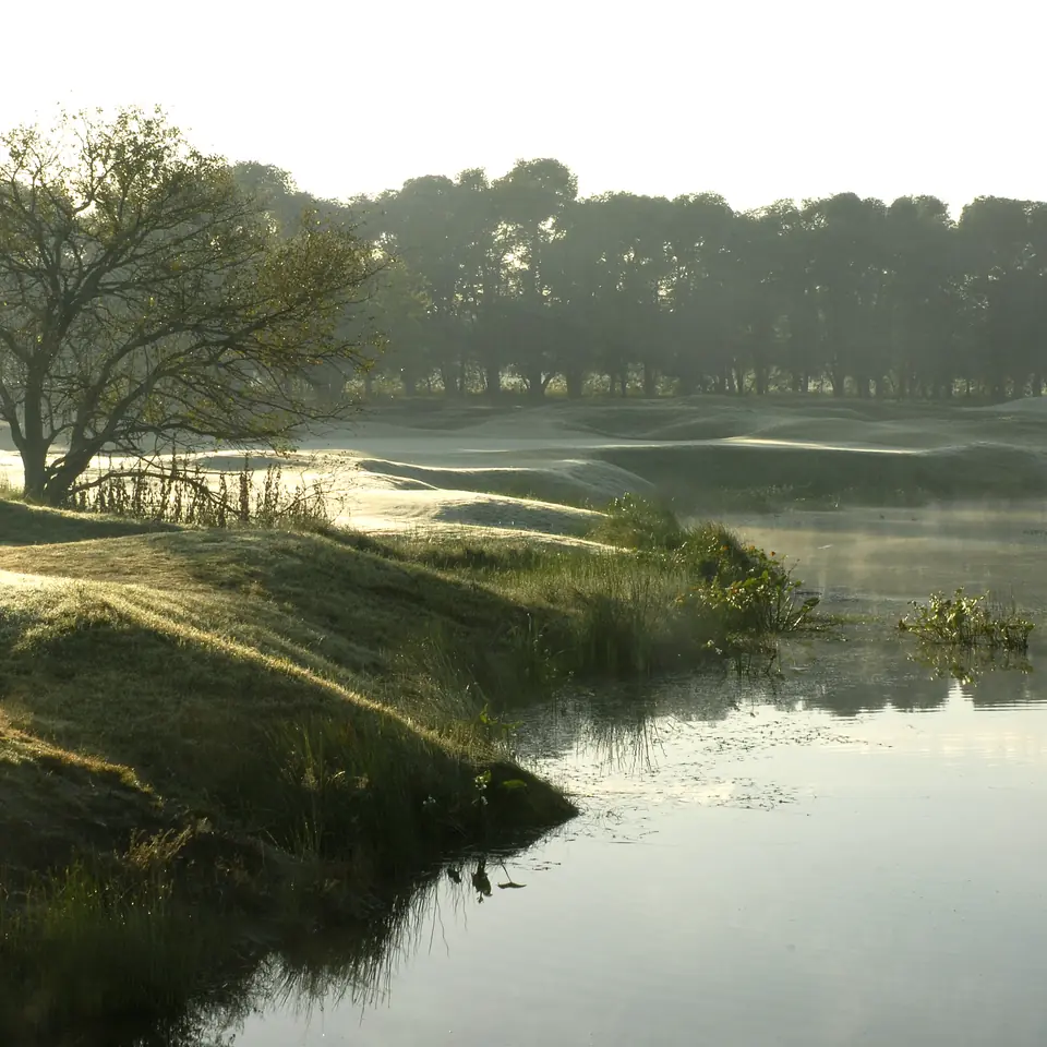 Mist over the water beside a fairway at Pilará